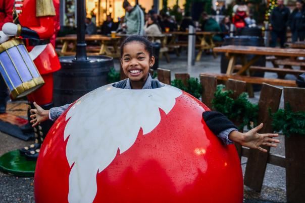 Girl smiling inside santa bauble at Christmas Market
