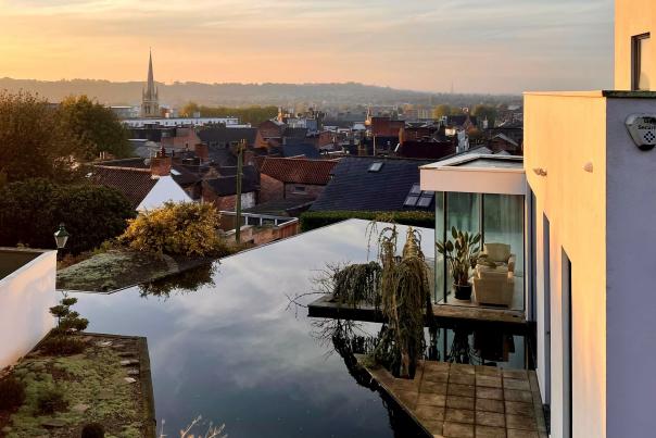 A sunset view of Lincoln from Michaelgate House with blue sky and an outdoor pool in the foreground