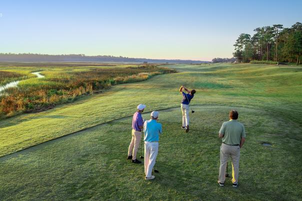 a golf group teeing off at Rivers Edge Golf Club in Shallotte, NC