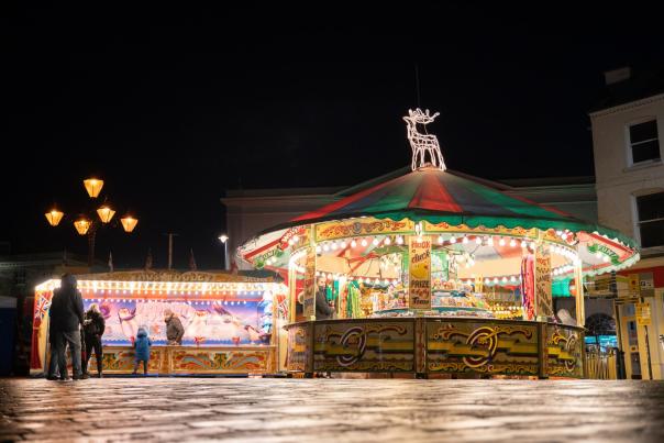 night shot of carnival games lit with festoon lights
