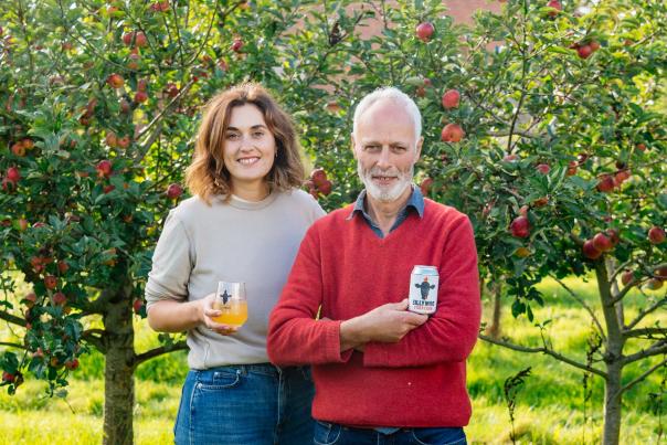 Two owners of Trenchmore Farm in Sussex standing in the cider orchard