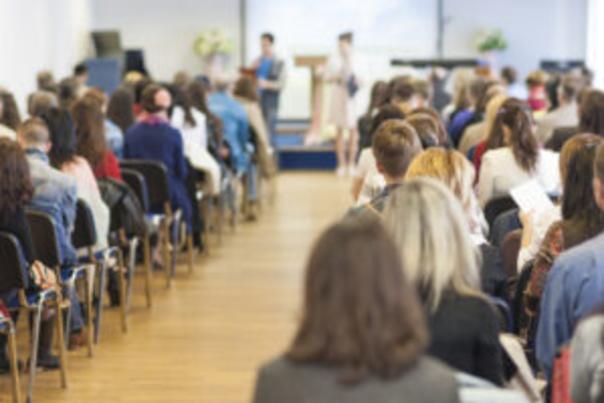 Room full of people seated listening to presenter