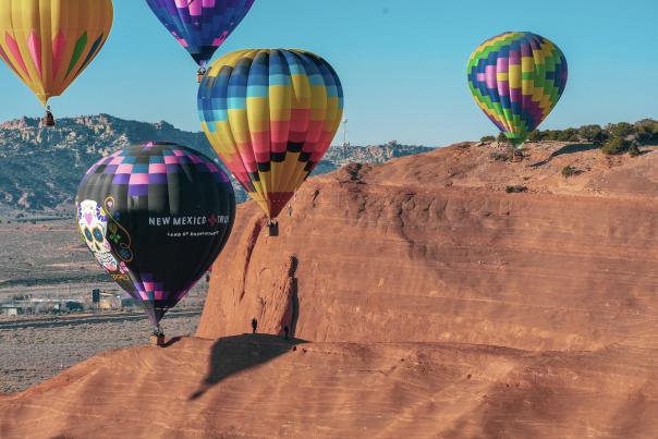A small group of hot air balloons fly over the Red Rock Park in Gallup, New Mexico