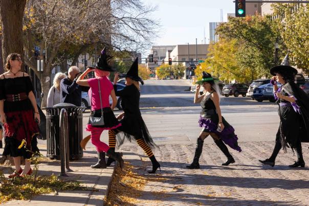 Old Market Witches Walk with people dressed as witches crossing a street.