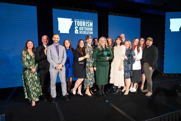 The Visit Bentonville staff poses for a photo with the Secretary of the Parks, Heritage, and Tourism, Director of Tourism, when accepting the award.