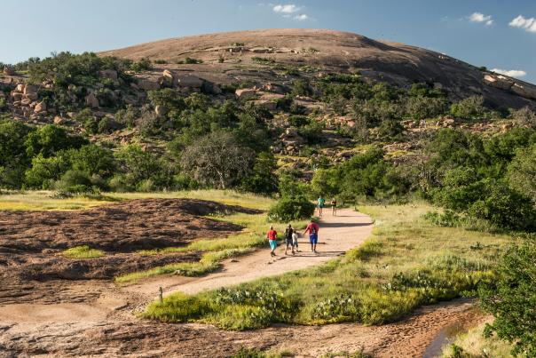 Family walking on path towards Enchanted Rock.