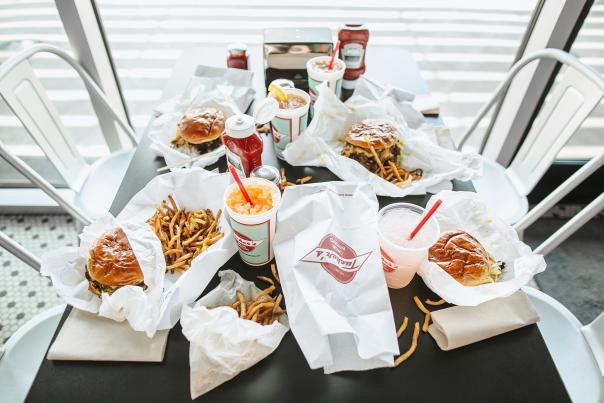 A table filled with fries, cheeseburgers and soft drinks at Tucker's Onion Burgers