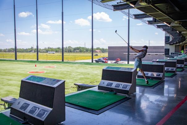 person golfing at an outdoor golf driving range