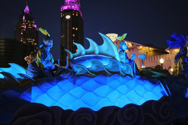 dragon Mardi Gras float at night with hi-rise buildings in the background