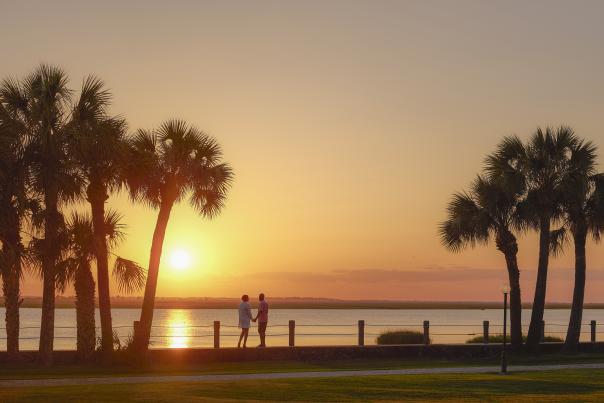 A couple enjoys the sunset along the Jekyll River in the Jekyll Island Historic District