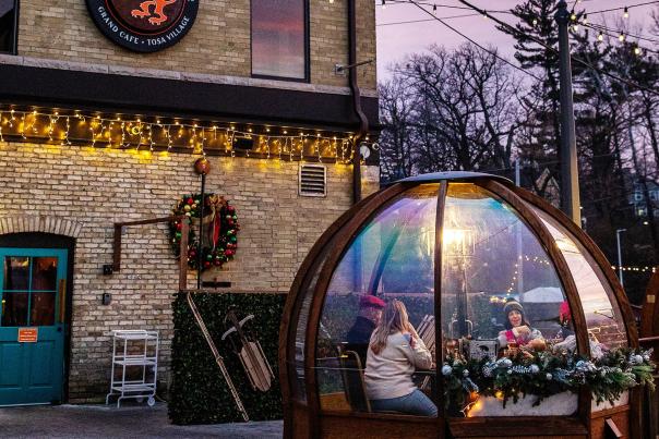 friends eating in a winter dome outside Cafe Hollander in wauwatosa