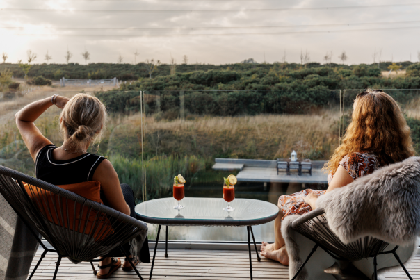 Two people relaxing with a drink, enjoying the view