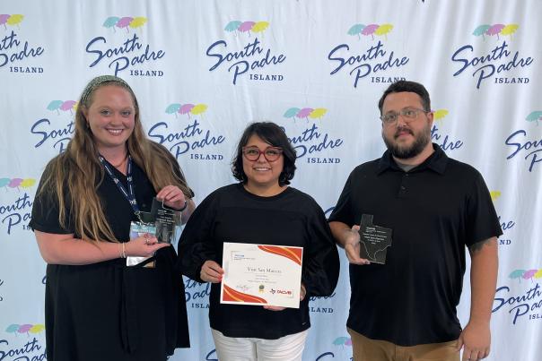 Sarah Smith, Rebecca Ybarra, and Steve Anderson pose with Visit San Marcos' Destination Excellence Awards in South Padre, Texas
