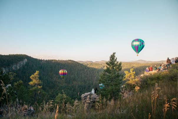 hot air balloons coming out of the Stratobowl canyon in the black hills of south dakota