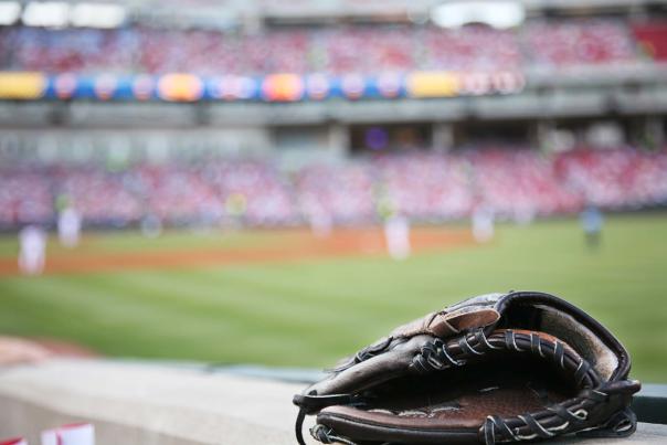 A baseball glove sits on the grass in a stadium