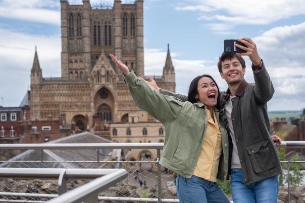 two people taking a selfie in front of Lincoln Cathedral
