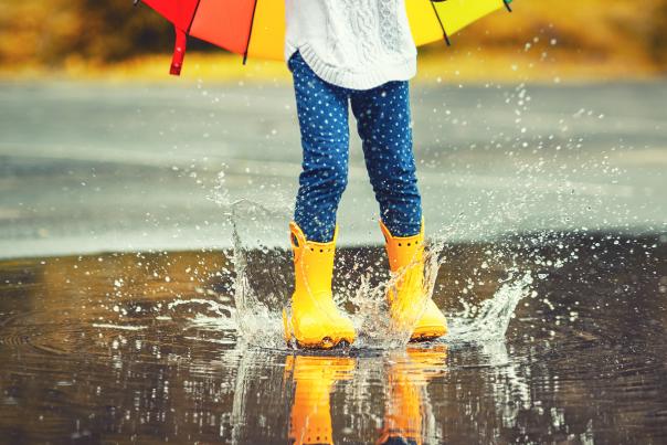 Girl in Yellow Boots splashing a Rain Puddle on a Rain Day