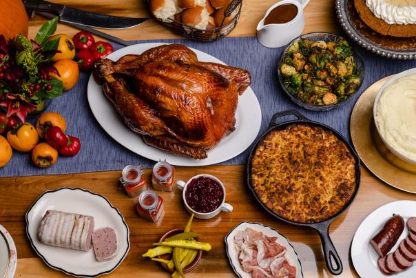 A Thanksgiving feast on wooden table including turkey and sides