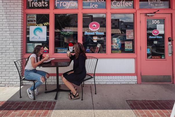 A mom and daughter enjoying breakfast on patio downtown outside of Sweet Bunz Donuts.