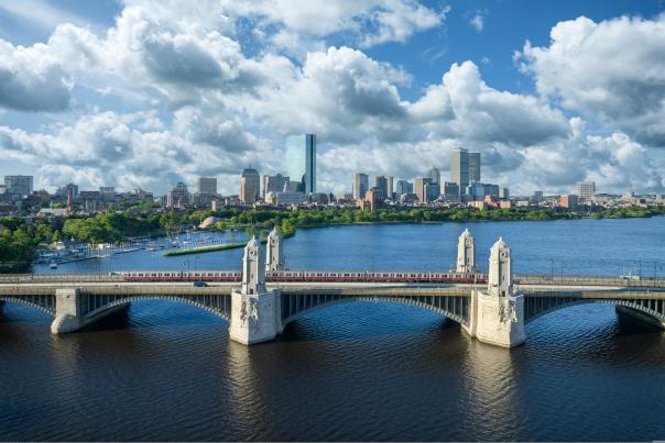 MBTA red line Train traveling over the Longfellow Bridge with the Boston skyline in the background.
