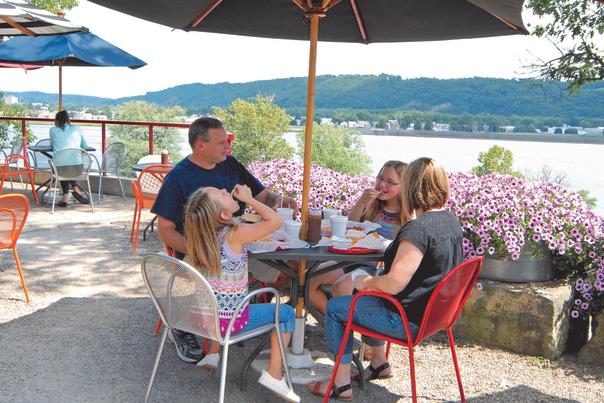 A family eats lunch at a local restaurant overlooking a river.