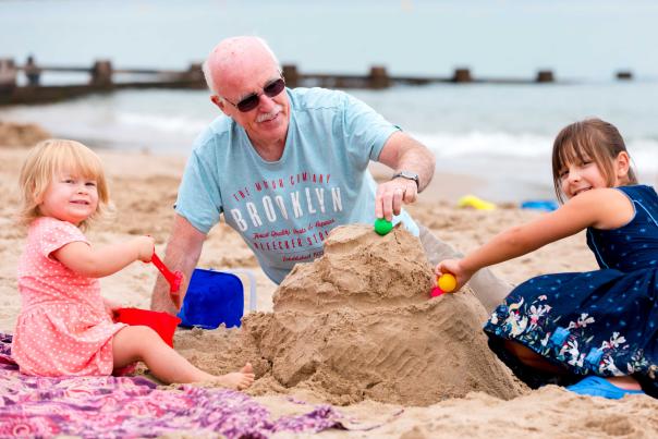 Family building sandcastles on Swanage Beach in Dorset