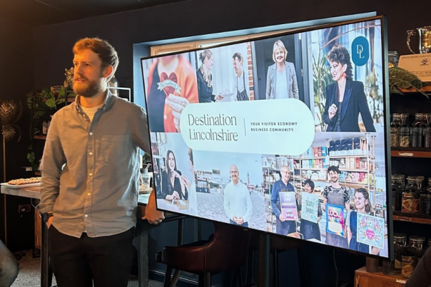 a man stood in front of a presentation screen which says Destination Lincolnshire