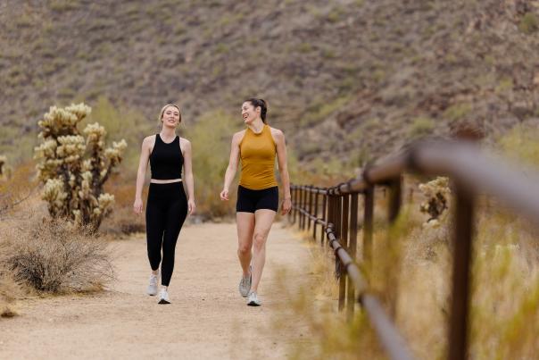 Two women walking on desert trail