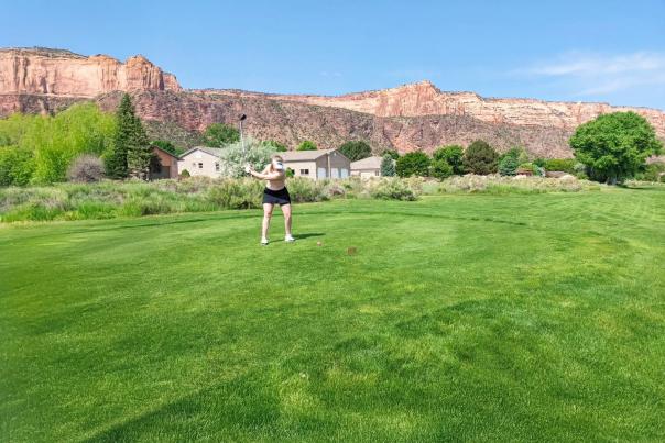 Woman Golfing with Colorado National Monument in the background