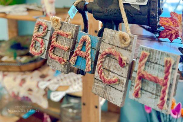 a coastal decor sign that spells out "beach" in red rope