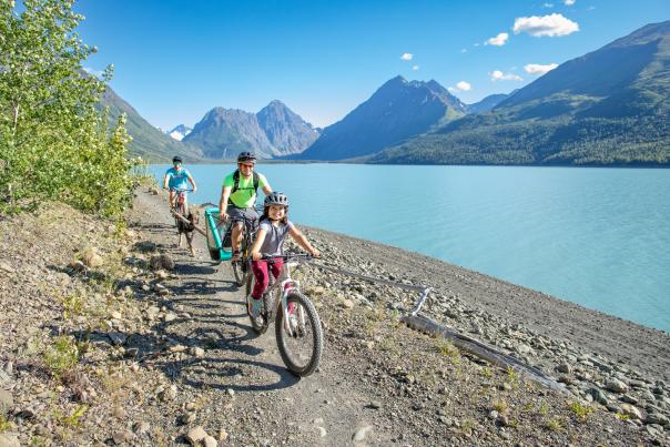A family bikes along the shore of Eklutna Lake.