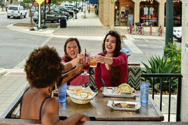 Group of women having lunch and cheers a drink