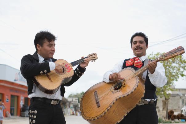 A pair of mariachi perform on their instruments