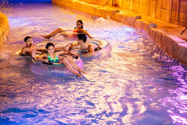 A family of four floating in a lazy river in Camelback Resort's indoor waterpark
