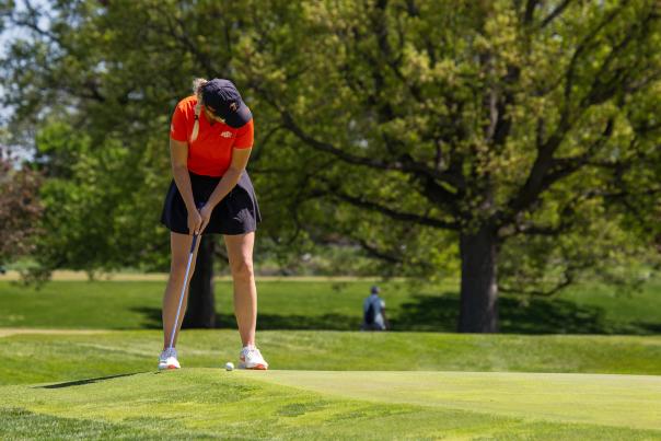 Golfer about to putt on the edge of the green