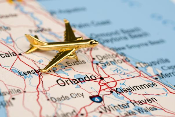 gold airplane laying on top of a map of florida
