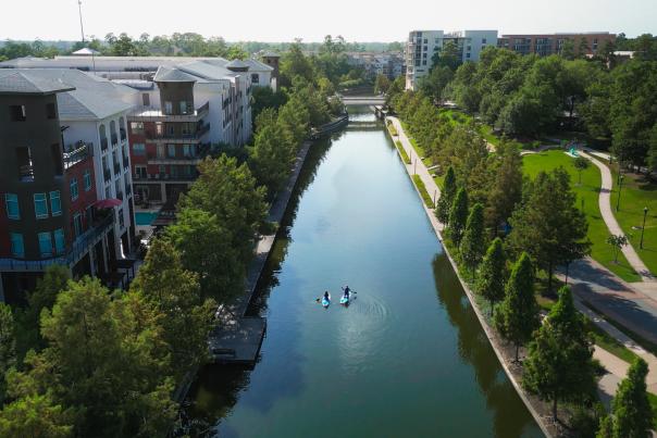 The Woodlands Waterway stretches past apartments at Riva Row and lush green pathways.