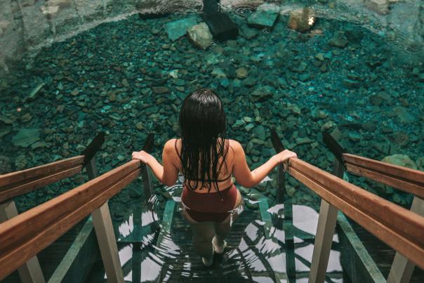 Woman descends stairs into the Warm Springs Pools at the Homestead Resort