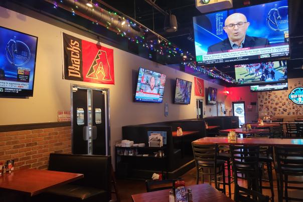 interior view of sports bar showing many tables and wall mounted tv's