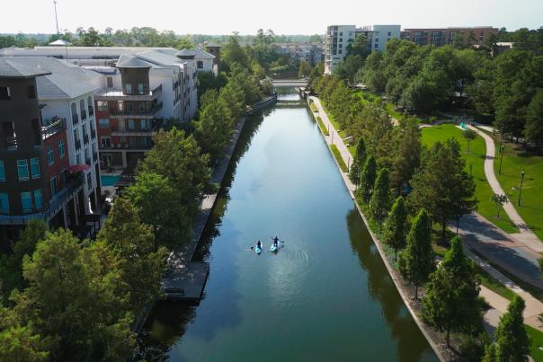The Woodlands Waterway stretches past apartments at Riva Row and lush green pathways.