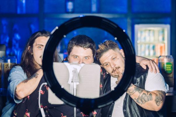 Three guys pose for a photo in front of a selfie light during a great concert at The Marc in Downtown San Marcos, Texas. You can find live music in San Marcos every night of the week!