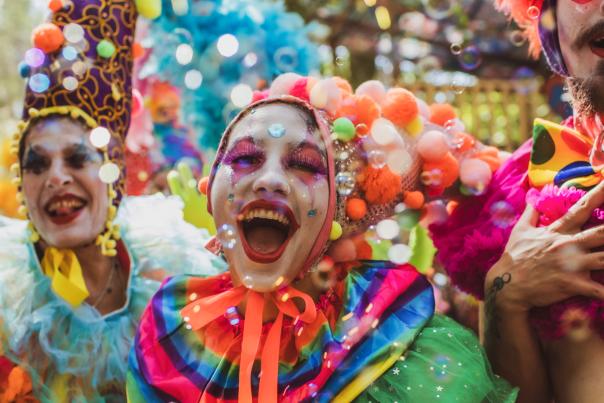 Laughing clowns use a bubble gun.