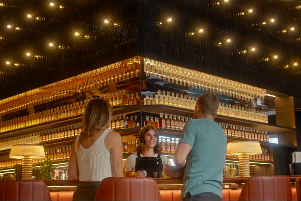 two people standing in front of the mixology bar ordering a cocktail
