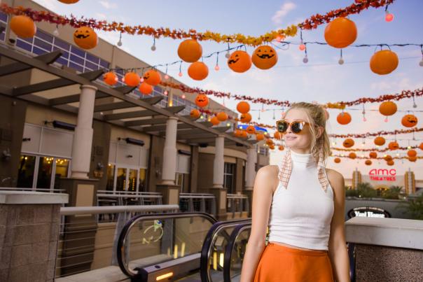 Photo of a woman posing in front of Halloween Pumpkins at Westgate Entertainment District.