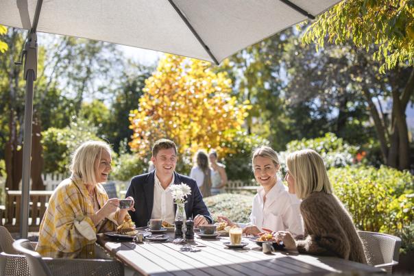 Group of people enjoying breakfast outside on a sunny autumn day