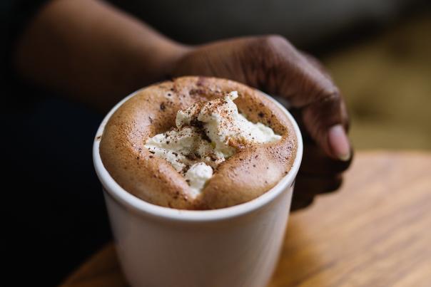 Hand holding mug of Seasonal Hot Chocolate from Northstar Cafe