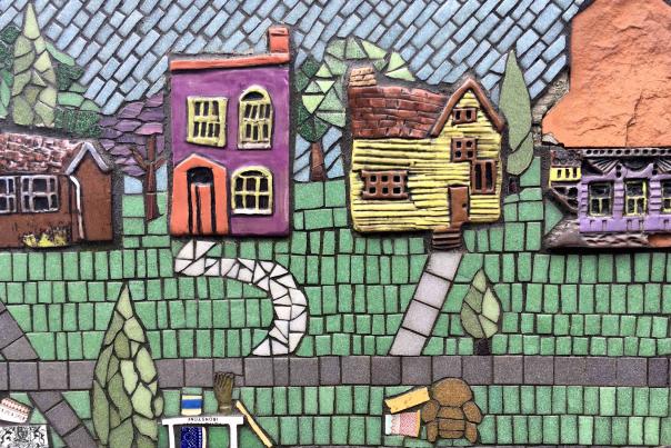 Closeup of a multi-colored mosaic showing houses and a street that's a public art work in Covington, Ky.