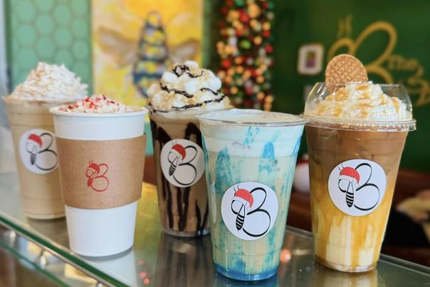 five holiday drinks from the buzz, lattes, coffees, and lotus drinks topped with chocolate, caramel, cookie butter, and peppermint