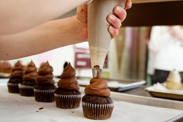 Piping frosting onto cupcakes