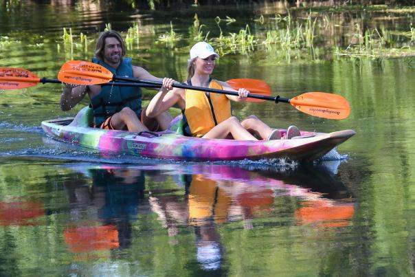 Couple in kayak paddling river